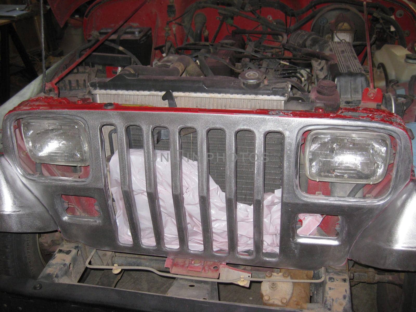 Auto Body Repair and Repainting Prep Work on Red Vehicle Grille. High quality photo