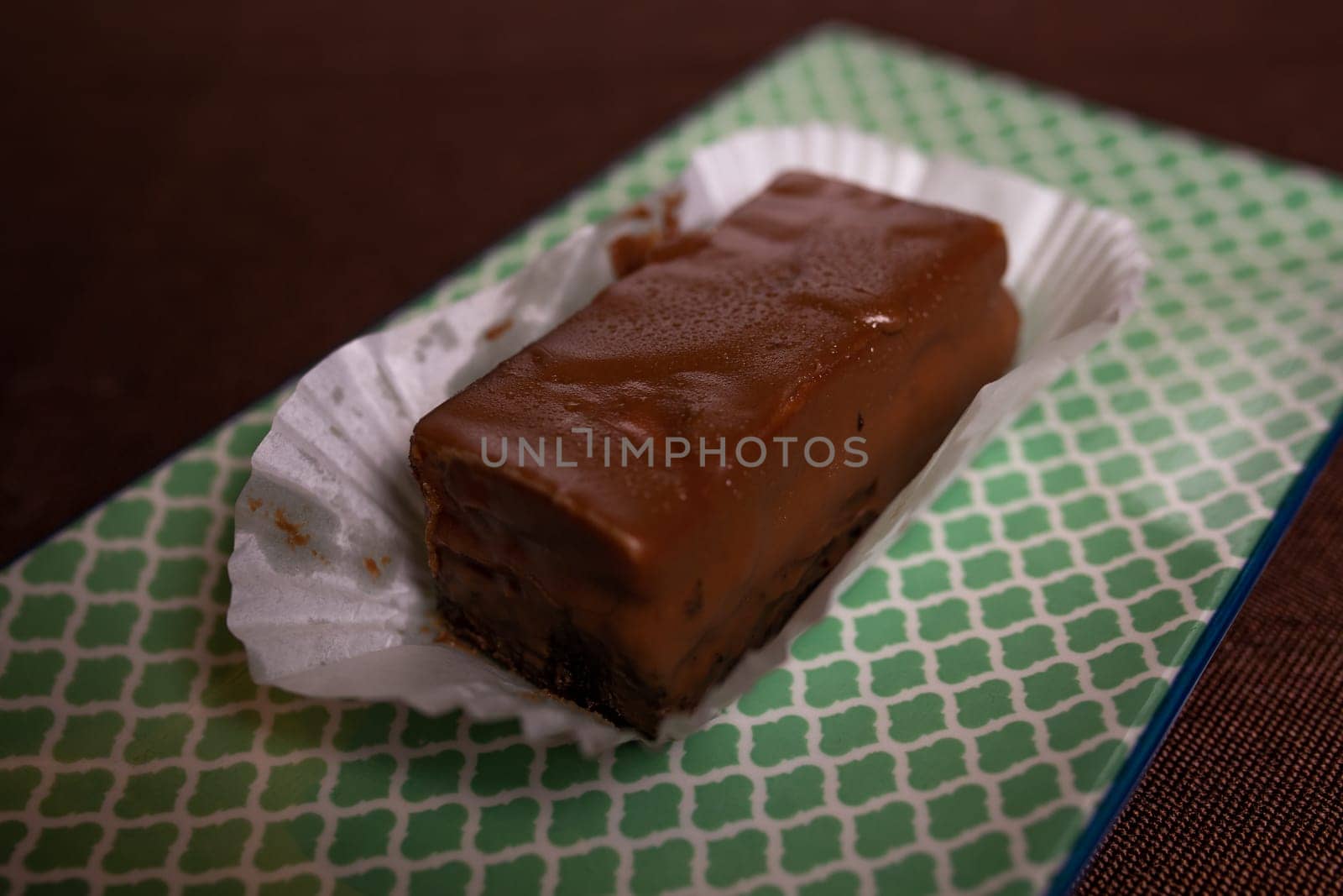 Rich and decadent chocolate fudge, highlighted on a light green background. chocolate dessert. by Pukhovskiy