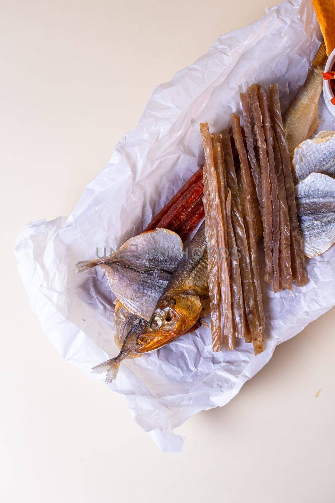 The smoked fish includes salmon, trout, and whitefish. The fish is served on a wooden board with a bowl of red pepper flakes.