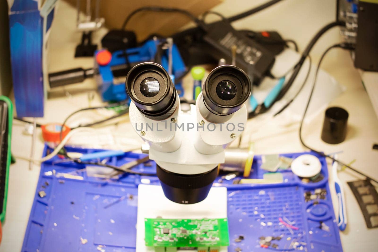 Modern engineering microscope over green board close up