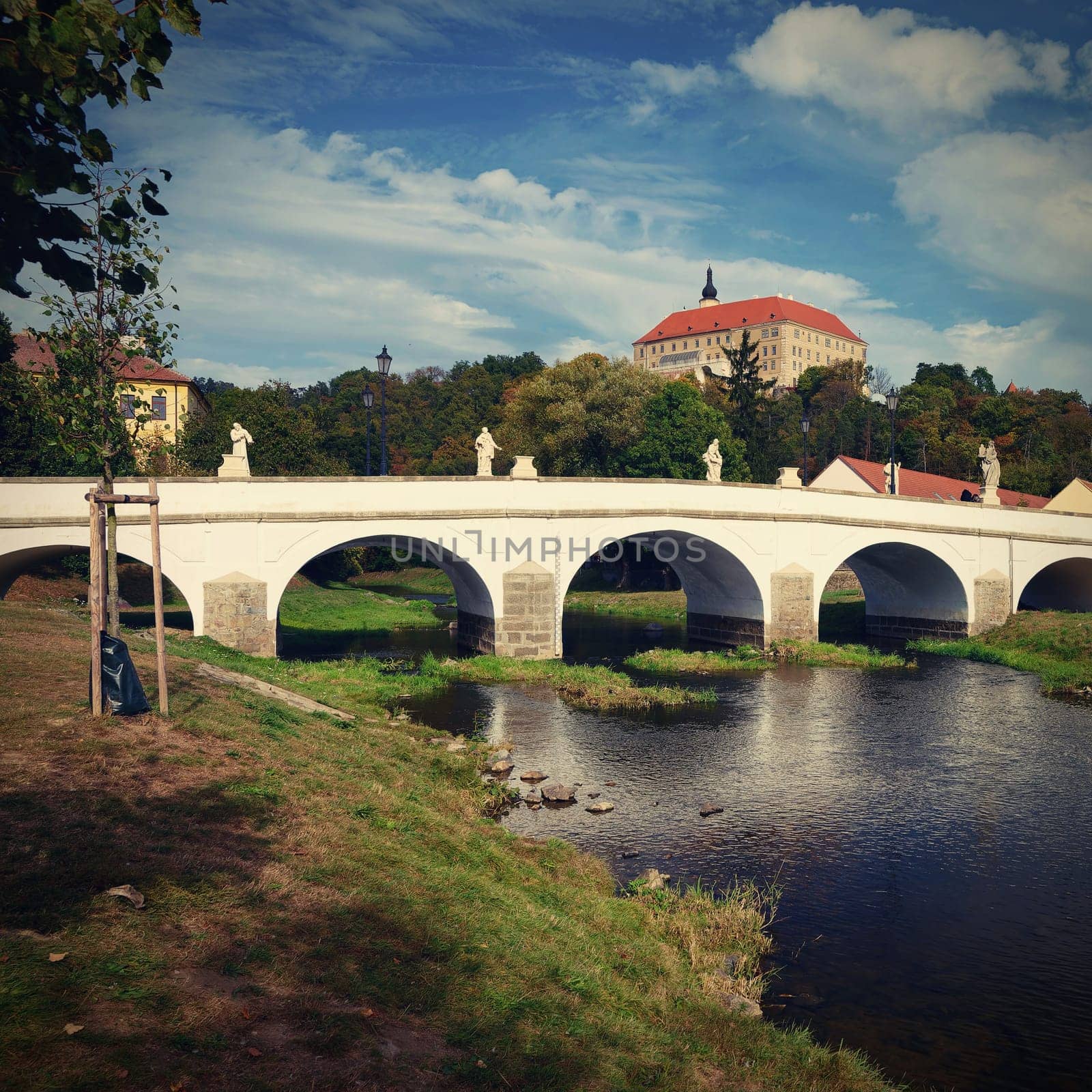 Beautiful old castle with a bridge over the river at sunset. European old architecture. Namest nad Oslavou - a city in the Czech Republic. by Montypeter