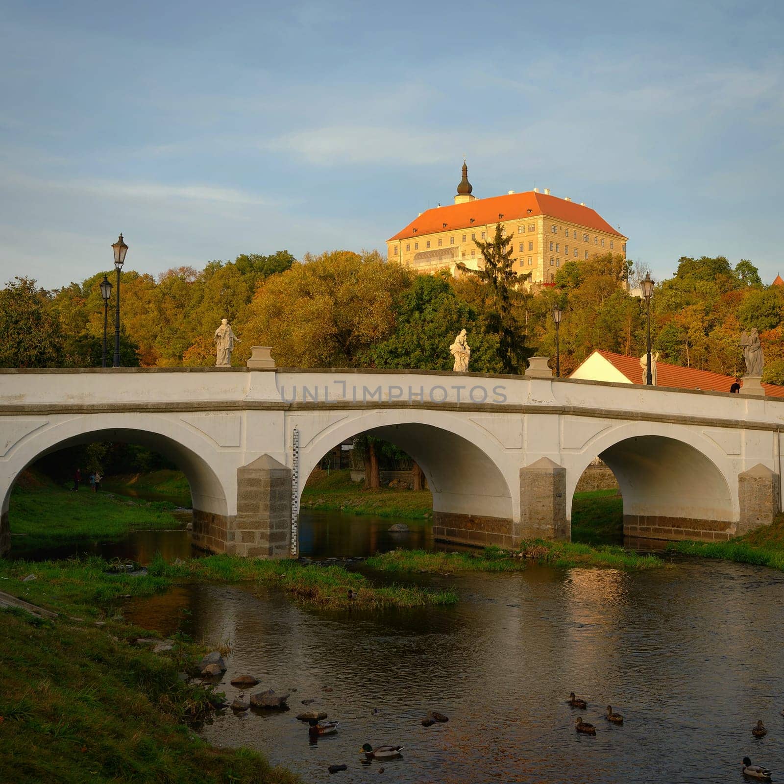 Beautiful old castle with a bridge over the river at sunset. European old architecture. Namest nad Oslavou - a city in the Czech Republic. by Montypeter