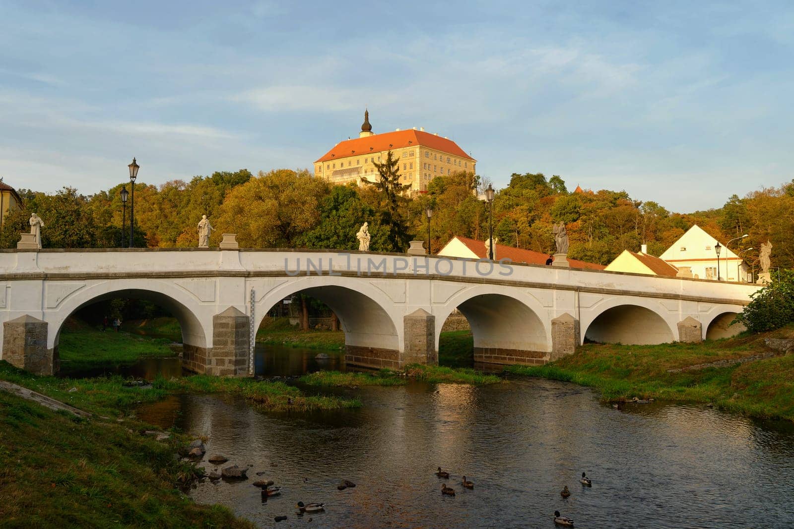 Beautiful old castle with a bridge over the river at sunset. European old architecture. Namest nad Oslavou - a city in the Czech Republic. by Montypeter