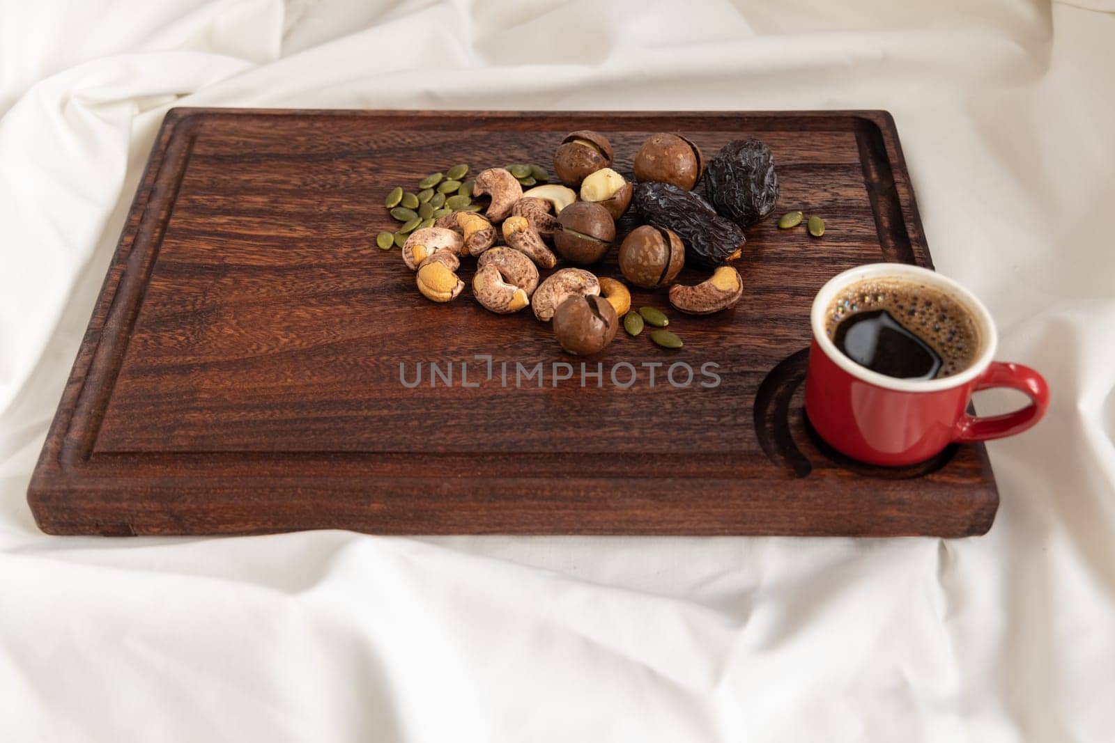 A tasty charcuterie board full of various nuts and coffee for breakfast