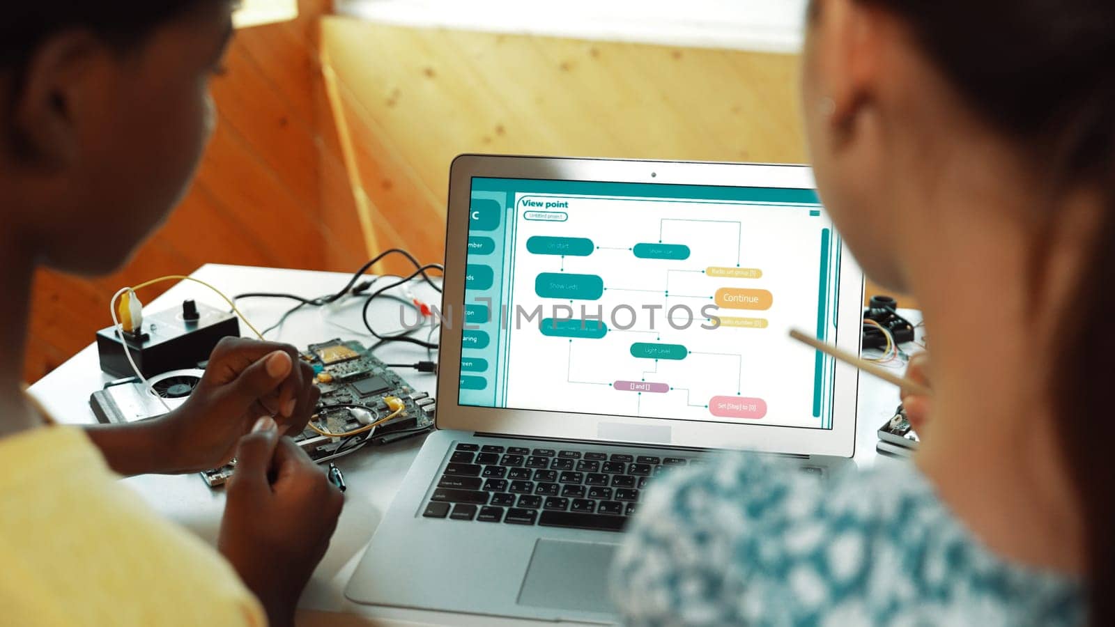 Laptop display coding system while student studying writing engineering code. Back view of diverse student learning programing system while pointing at screen at STEM technology class. Edification.