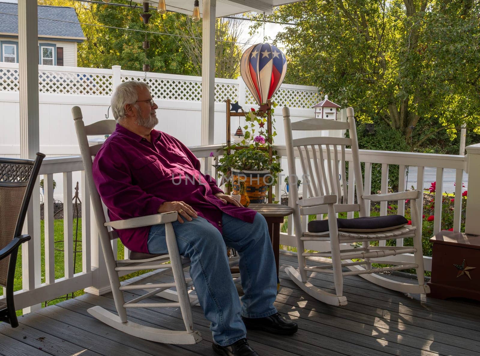 A Senior Aged Male Resting in a Rocking Chair, on a Deck, Enjoying His Retirement on a Autumn Day