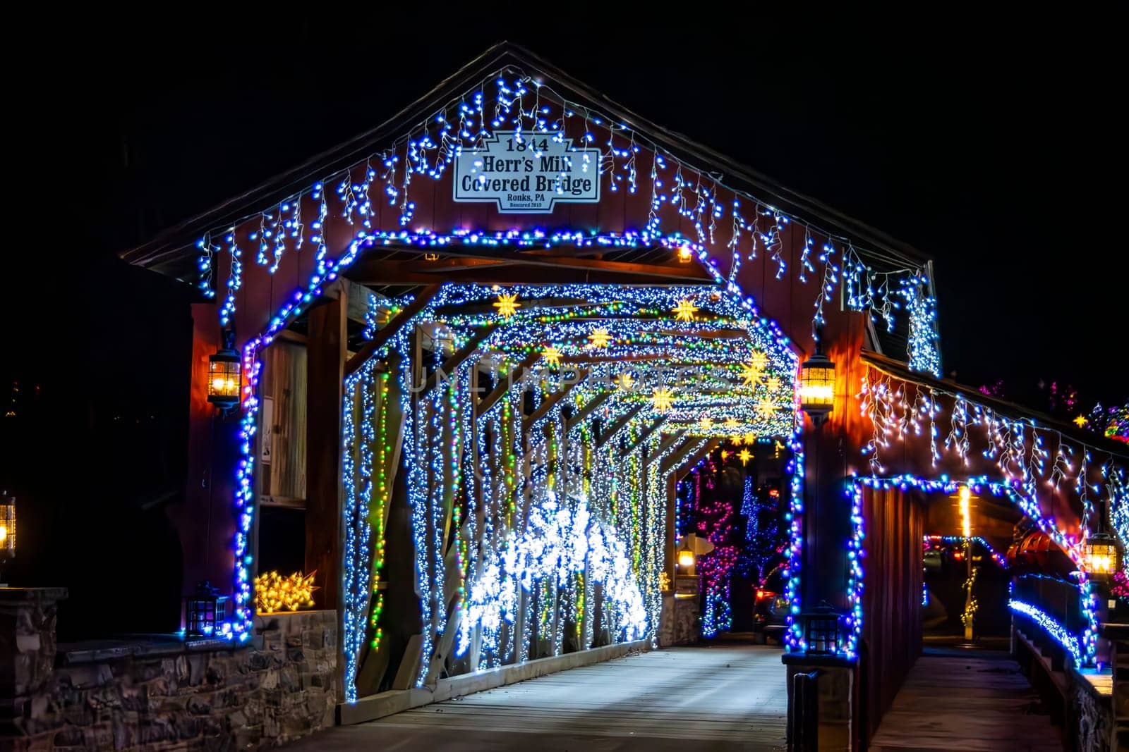 Elizabethtown, Pennsylvania, USA, December 8,2023 - Entrance Of Herr's Mill Covered Bridge Adorned With Twinkling Blue And White Christmas Lights And A, Creating A Magical Nighttime Scene.