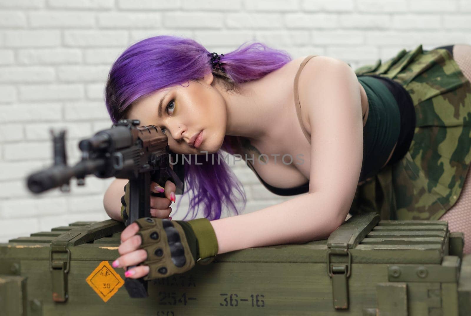 hot girl in a short sexy military skirt with a Kalashnikov assault rifle and a gun case on a brick wall background copy paste by Rotozey