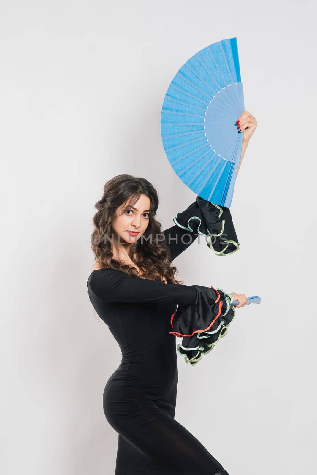 Portrait of beautiful young woman dancing flamenco in studio by Zelenin