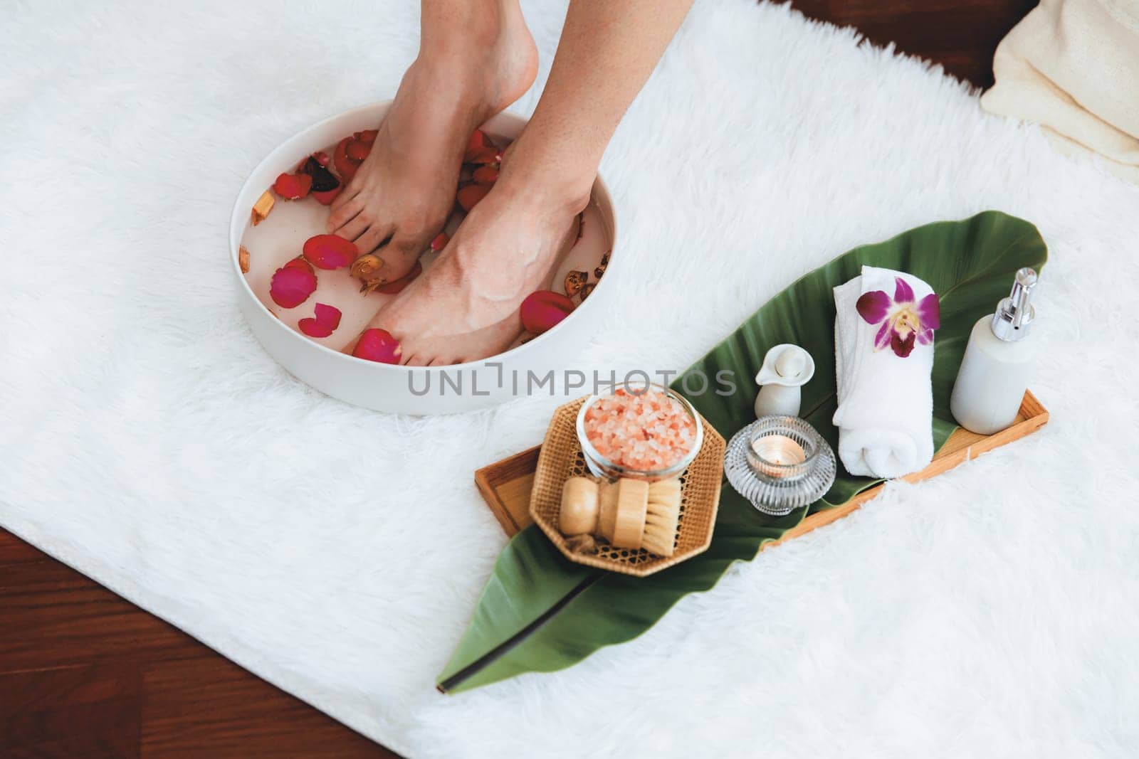 Man indulges in blissful foot massage at luxurious spa salon while masseur give reflexology therapy in gentle day light ambiance resort or hotel foot spa. Quiescent