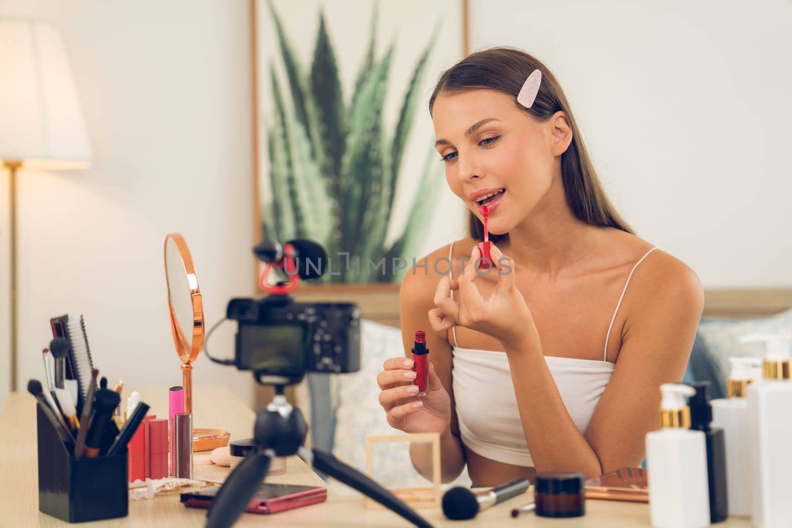 Young woman making beauty and cosmetic tutorial video content for social media. Beauty blogger smiles to camera while showing how to beauty care to audience or followers. Unveiling