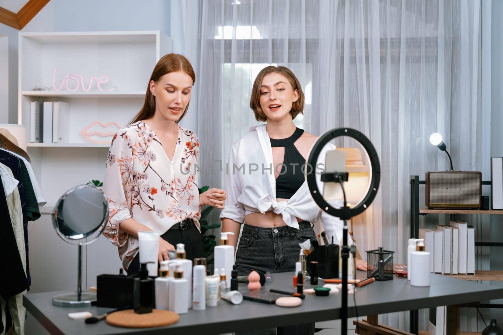 Woman influencer shoot live streaming vlog video review makeup utmost social media or blog. Happy young girl with cosmetics studio lighting for marketing recording session broadcasting online.