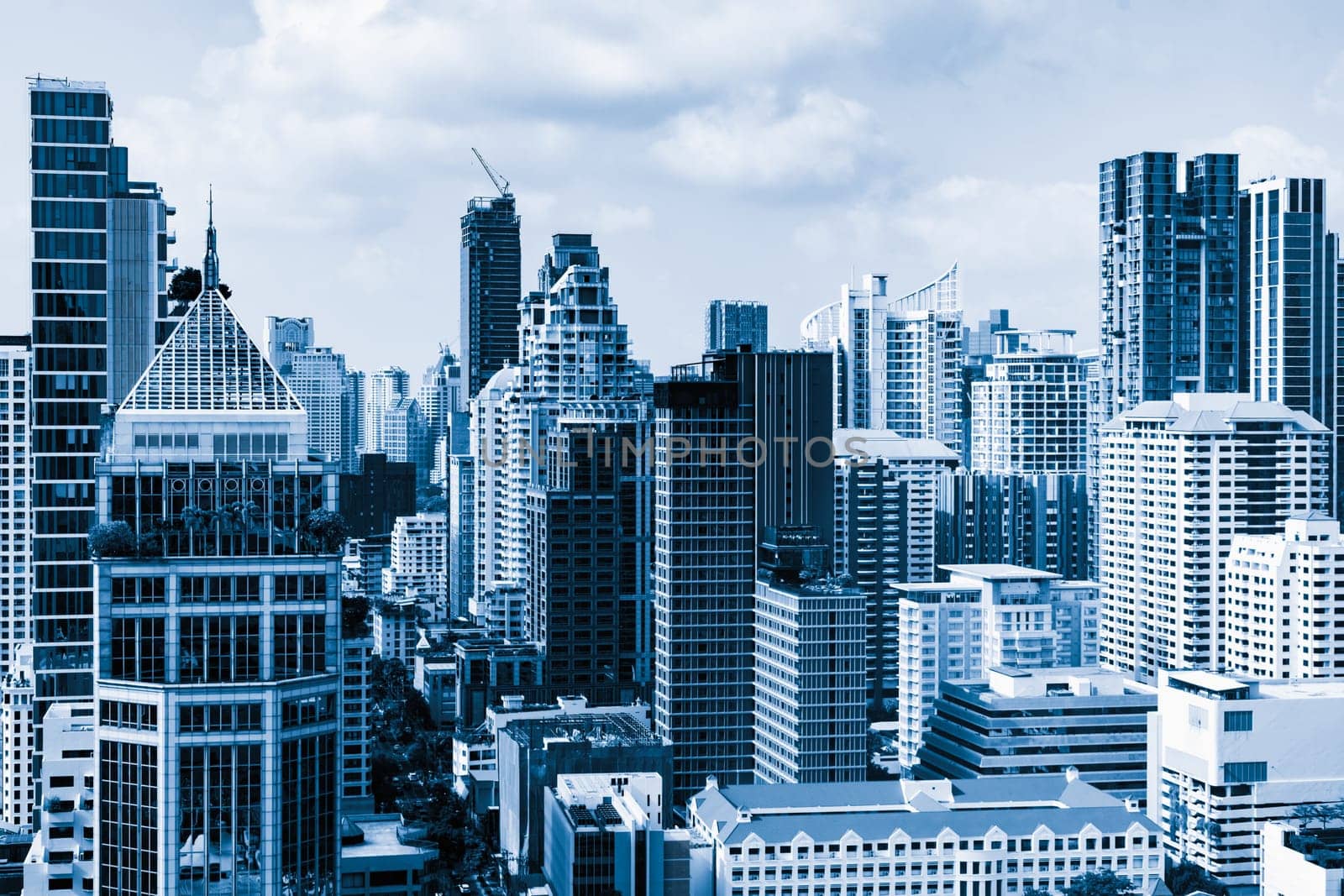 Closeup image of Bangkok cityscape. Modern skyscrapers with monochrome blue filter. Modern architectural building skyline with blue sky. Side view. Business background. Day light. Ornamented.