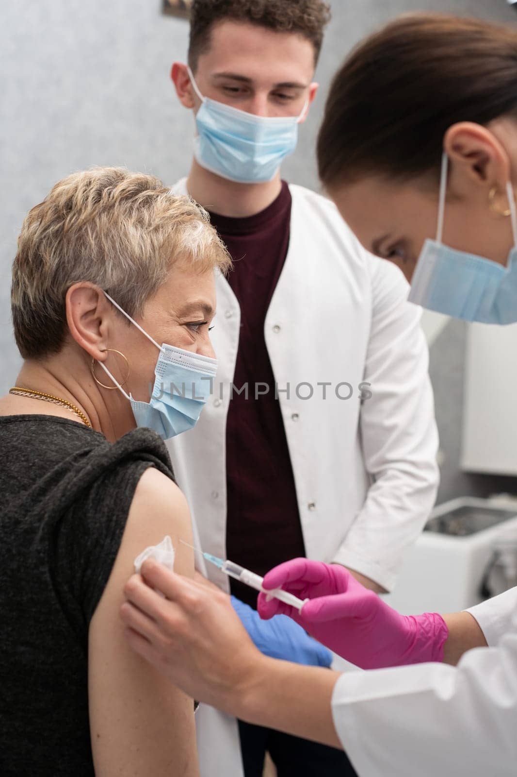 A young nurse injects a woman in her 50s with a new COVID19 vaccine. An injection with a new vaccine to support the body and increase resistance to infectious diseases.