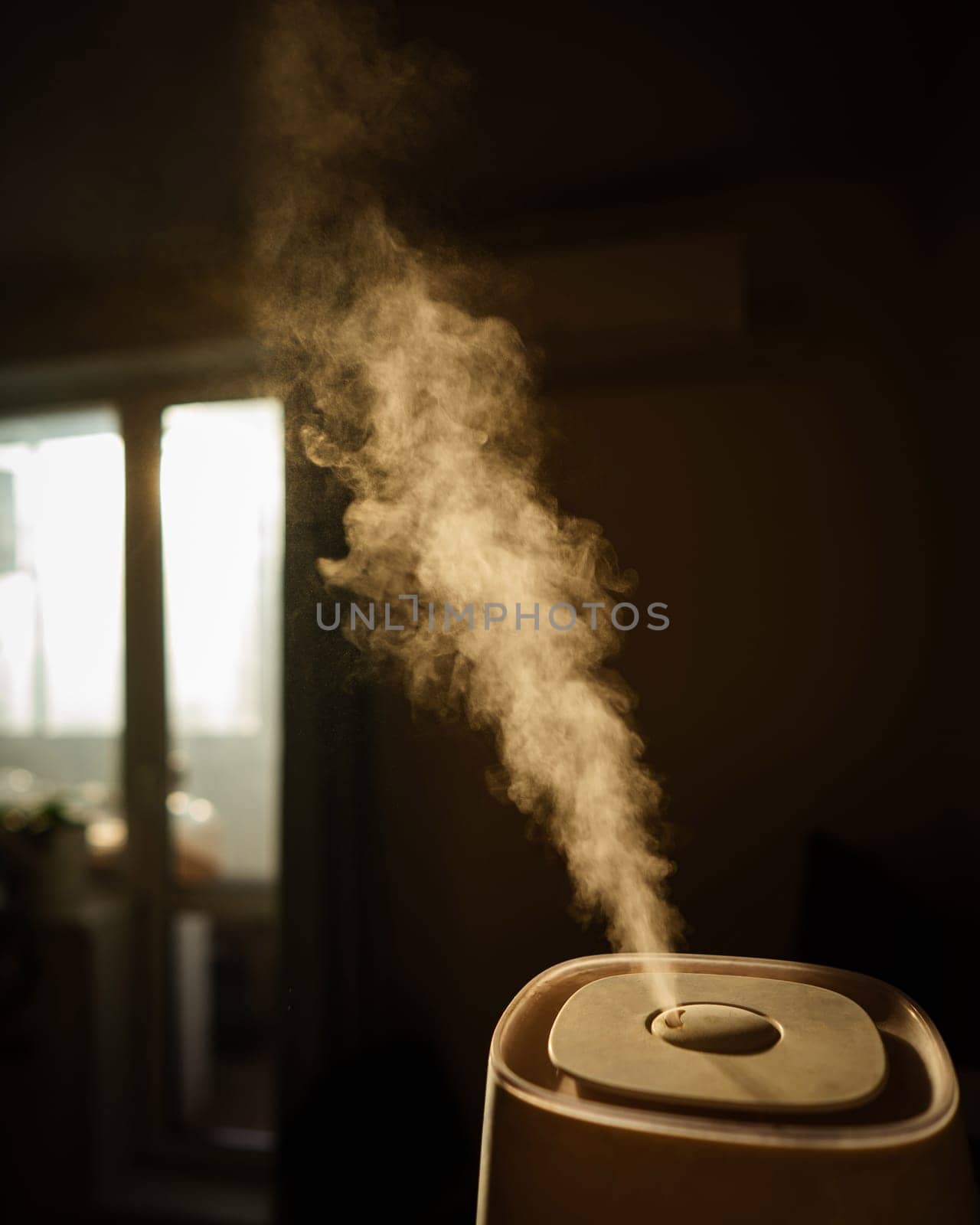 A humidifier evaporates moisture in the bedroom. Vertical photo. by mrwed54