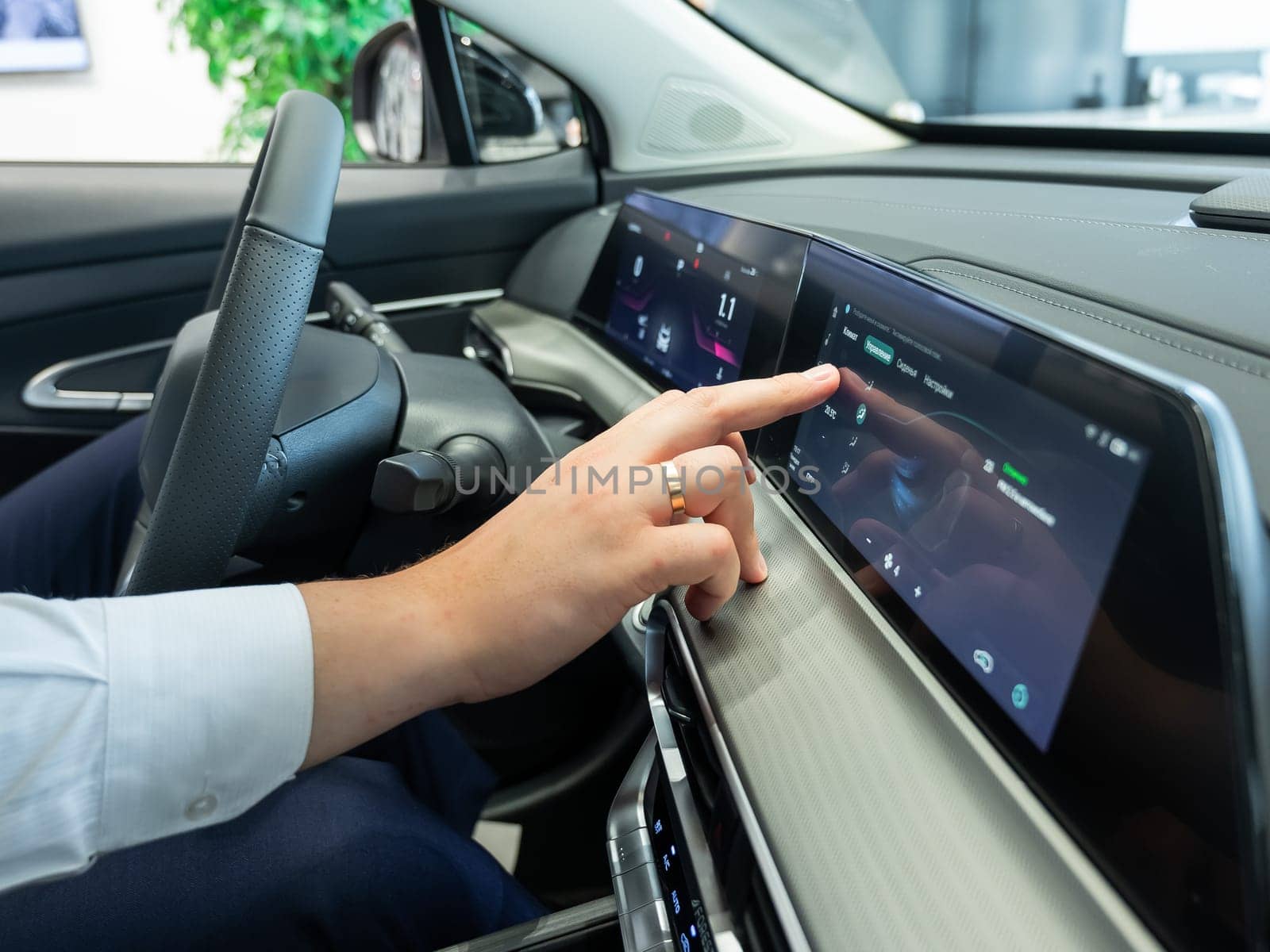Close-up of a man's hands on the dashboard of a modern car