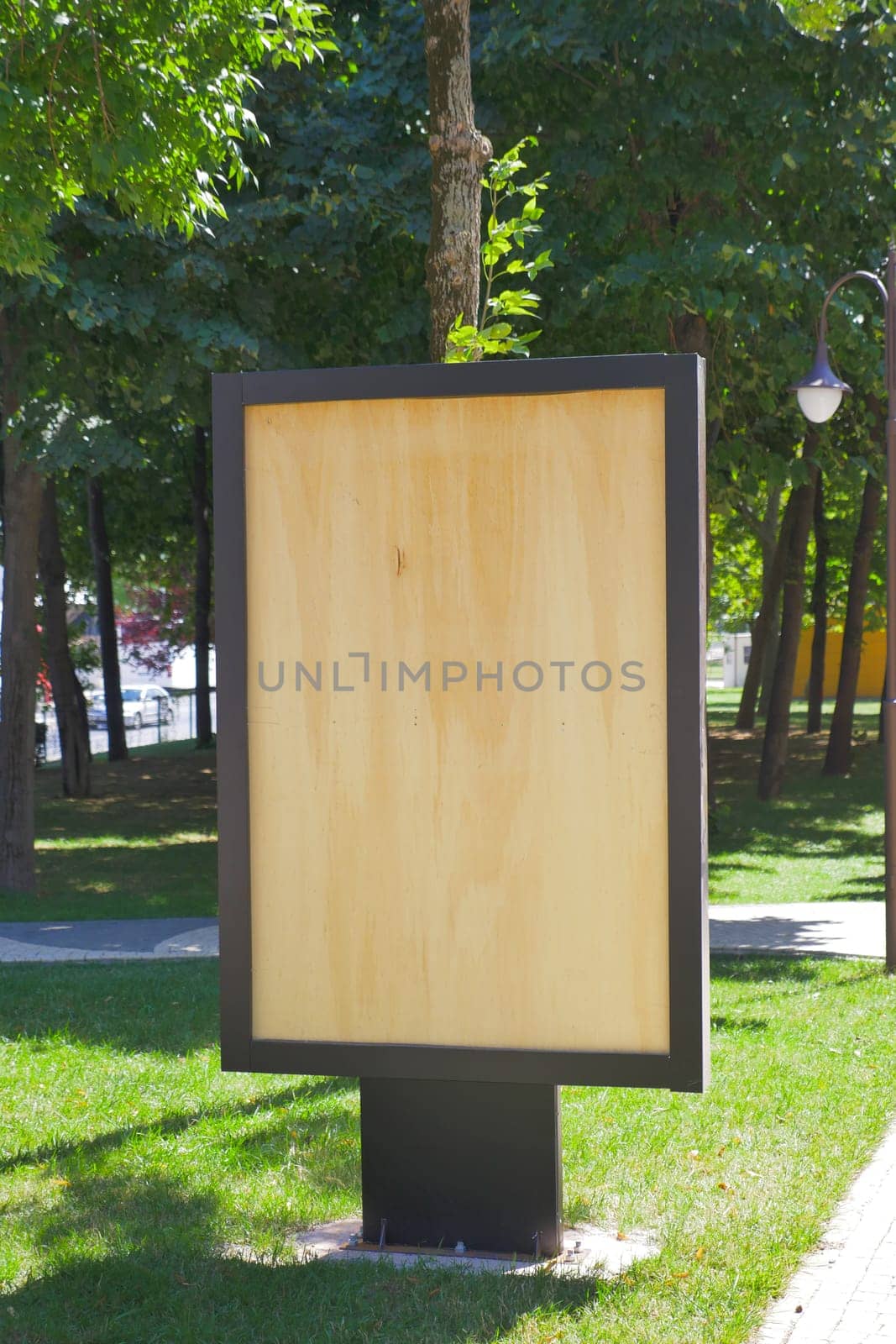 A wooden billboard stands in the park,