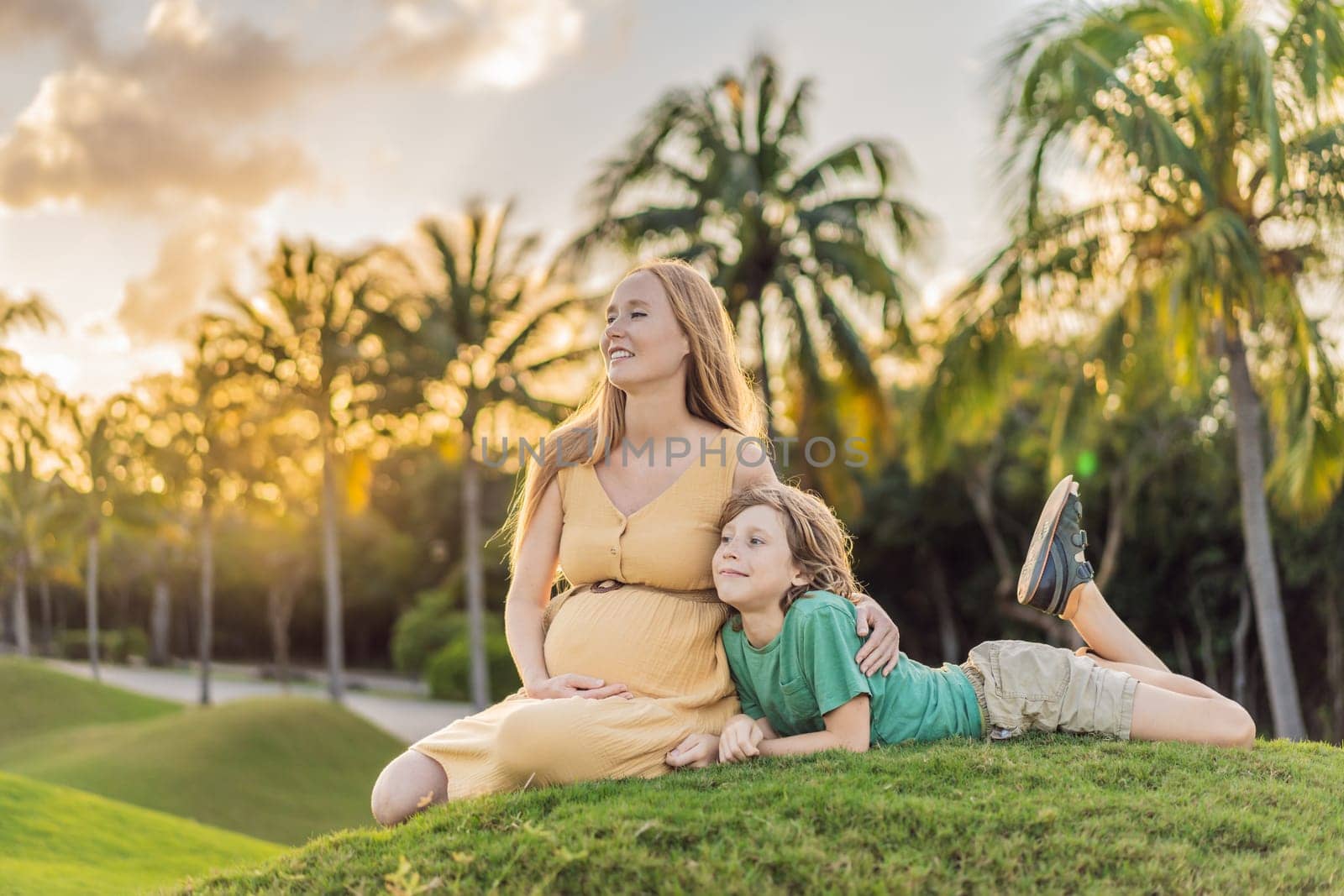 Heartwarming outdoor bonding as a pregnant mom and her son enjoy quality time together, savoring the beauty of nature and creating cherished moments by galitskaya