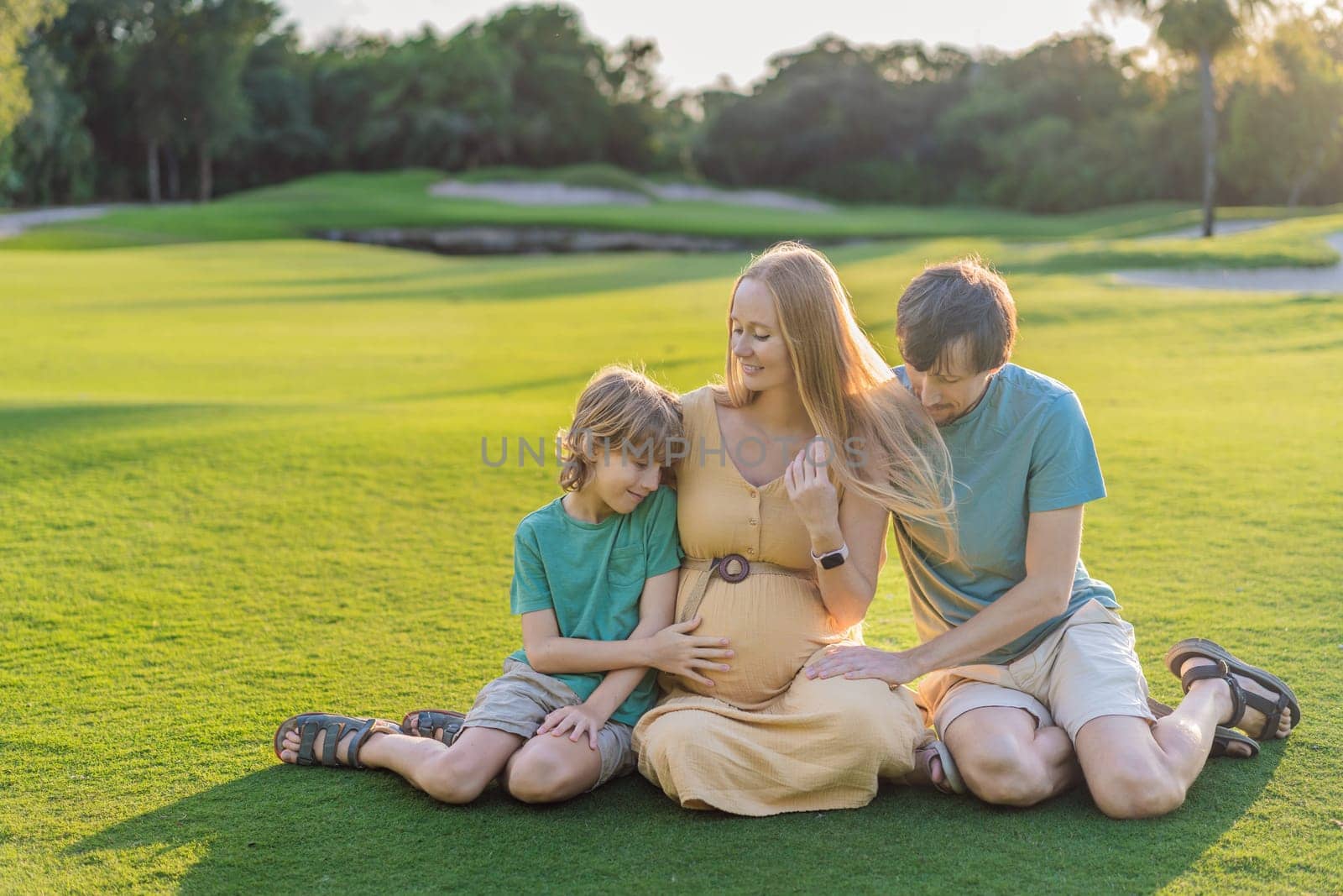 Joyful family time as a pregnant woman, her husband, and son share quality moments outdoors, embracing the beauty of nature and creating cherished memories together by galitskaya