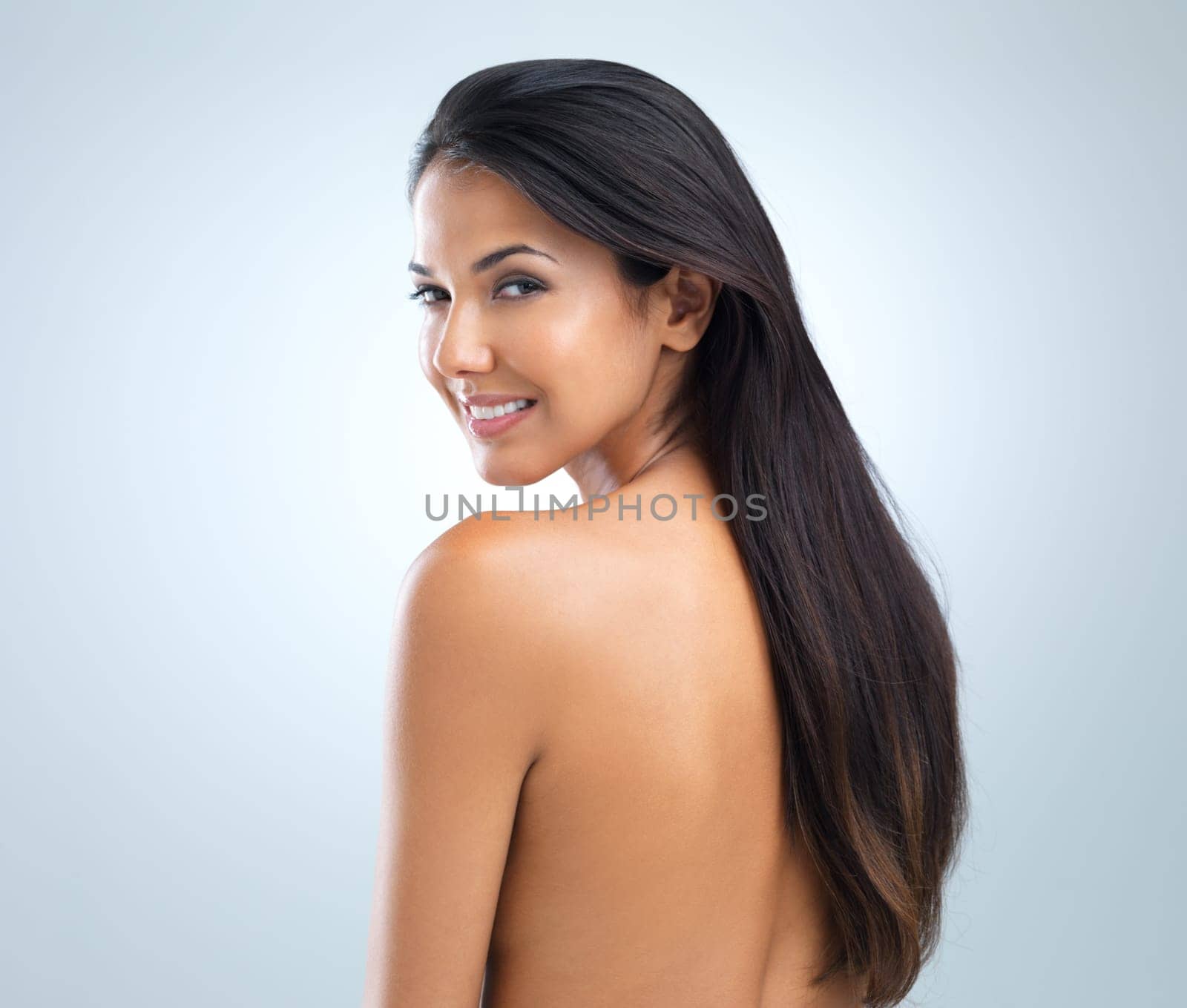 Woman, beauty and hair with cosmetics, model in studio with shine and keratin treatment on grey background. Haircare, cosmetology and skin for wellness, texture and growth in portrait with smile.