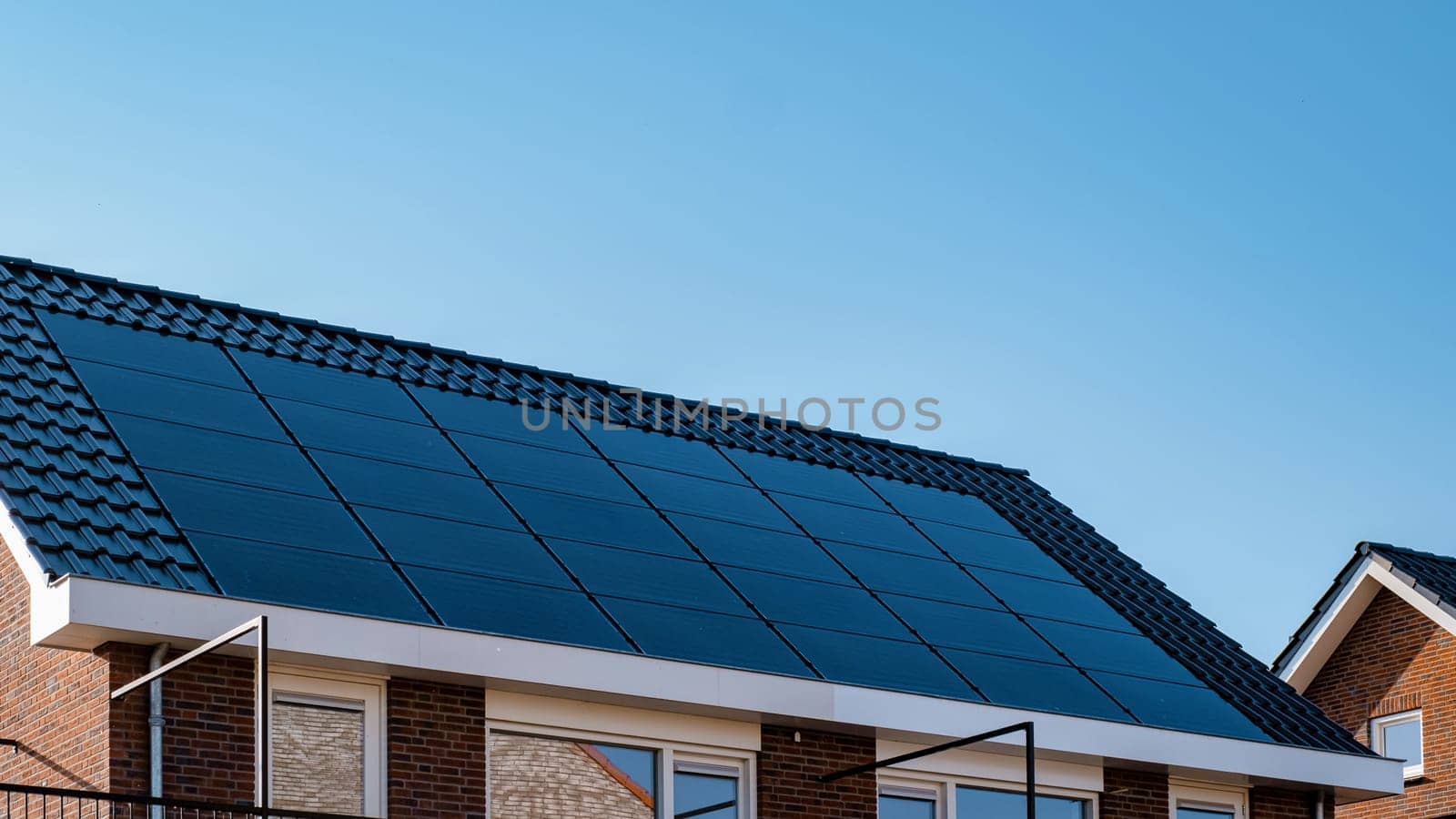 Newly build houses with solar panels attached on the roof against a sunny sky by fokkebok