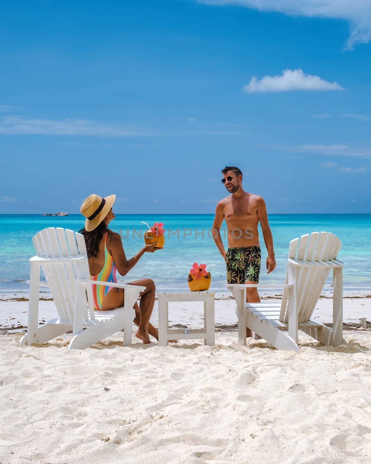 couple men and women on the beach with coconut drink, Praslin Seychelles tropical island by fokkebok