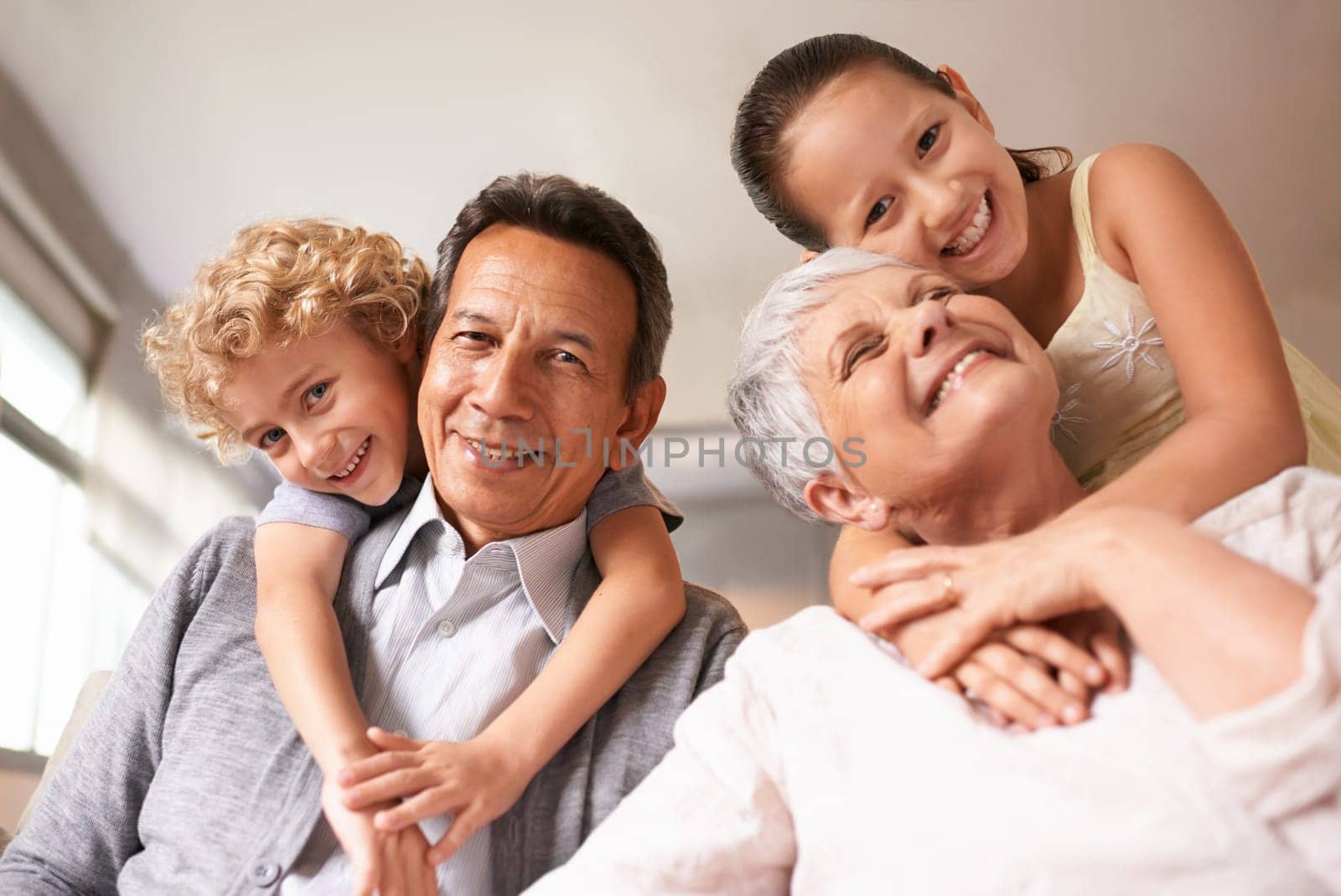 Portrait, grandparents and grandchildren with smile for family, photo and multi generation bonding. Senior couple, boy and girl with hug, love and happiness for playful relationship together at home.