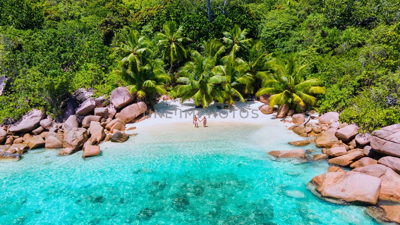 couple men and women vacation at the Seychelles visiting the tropical beach of Anse Lazio by fokkebok