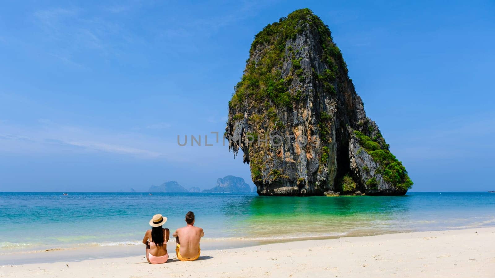 couple of men and woman relaxing on the beach during vacation in Thailand Railay Beach Krabi by fokkebok