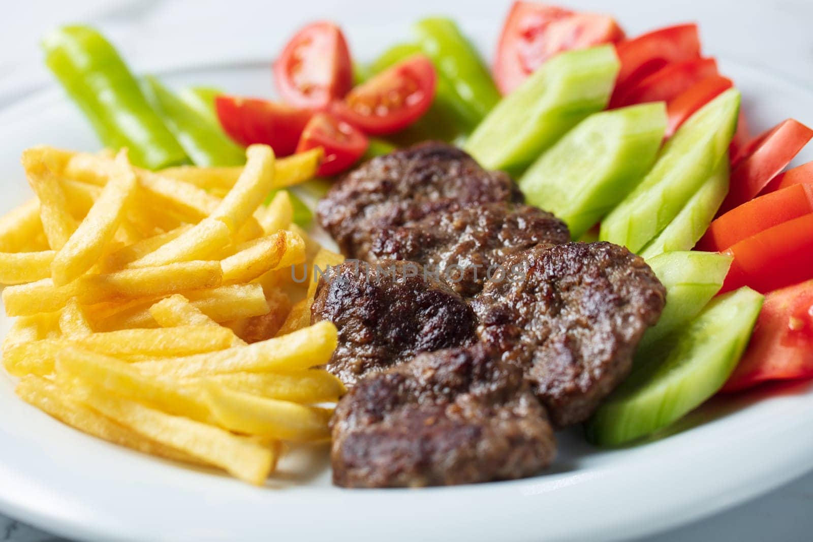 Traditional Turkish meatballs served with French fries tomatoes by senkaya