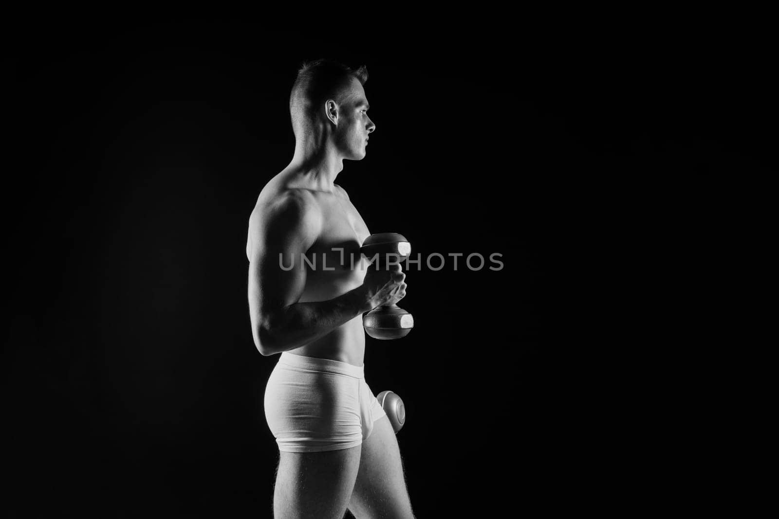 Dumbbells, fitness and man in a studio for training, exercise or bodybuilding studio shot.