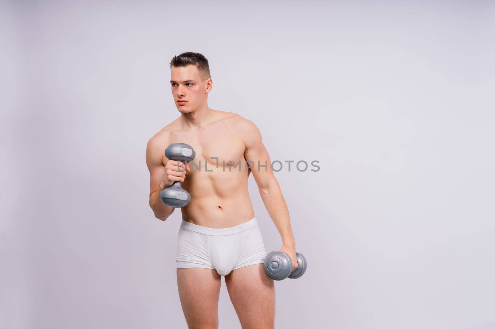 Dumbbells, fitness and man in studio for training, exercise or bodybuilding studio shot. by Zelenin