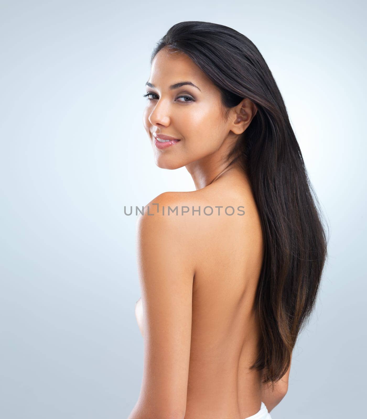 Woman, beauty and hair with shine, portrait of model in studio with cosmetics and keratin treatment on grey background. Haircare, cosmetology and touching skin for wellness with texture and growth.