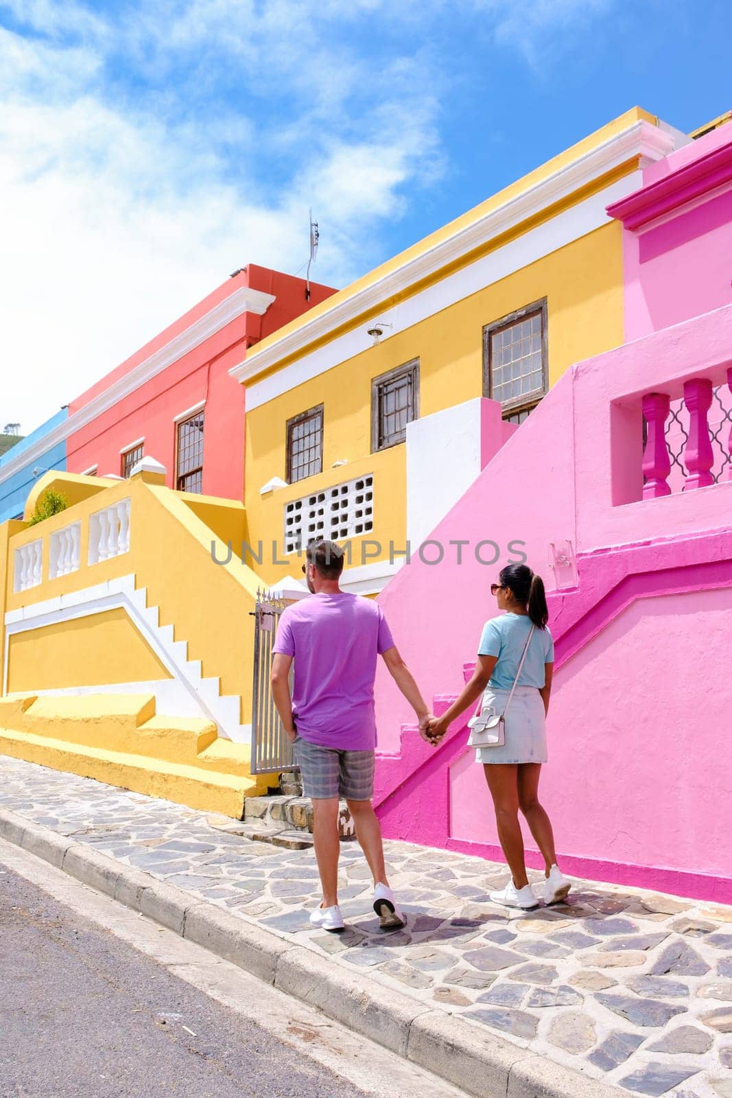 couple walking at the colorful streets of Bo Kaap in Cape Town,South Africa by fokkebok
