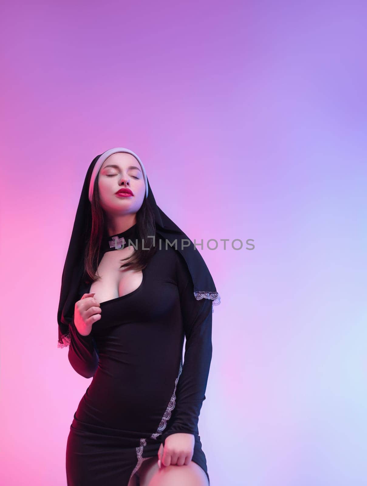 nun girl in a sexy dress defiantly poses naked on a neon background of a copy paste