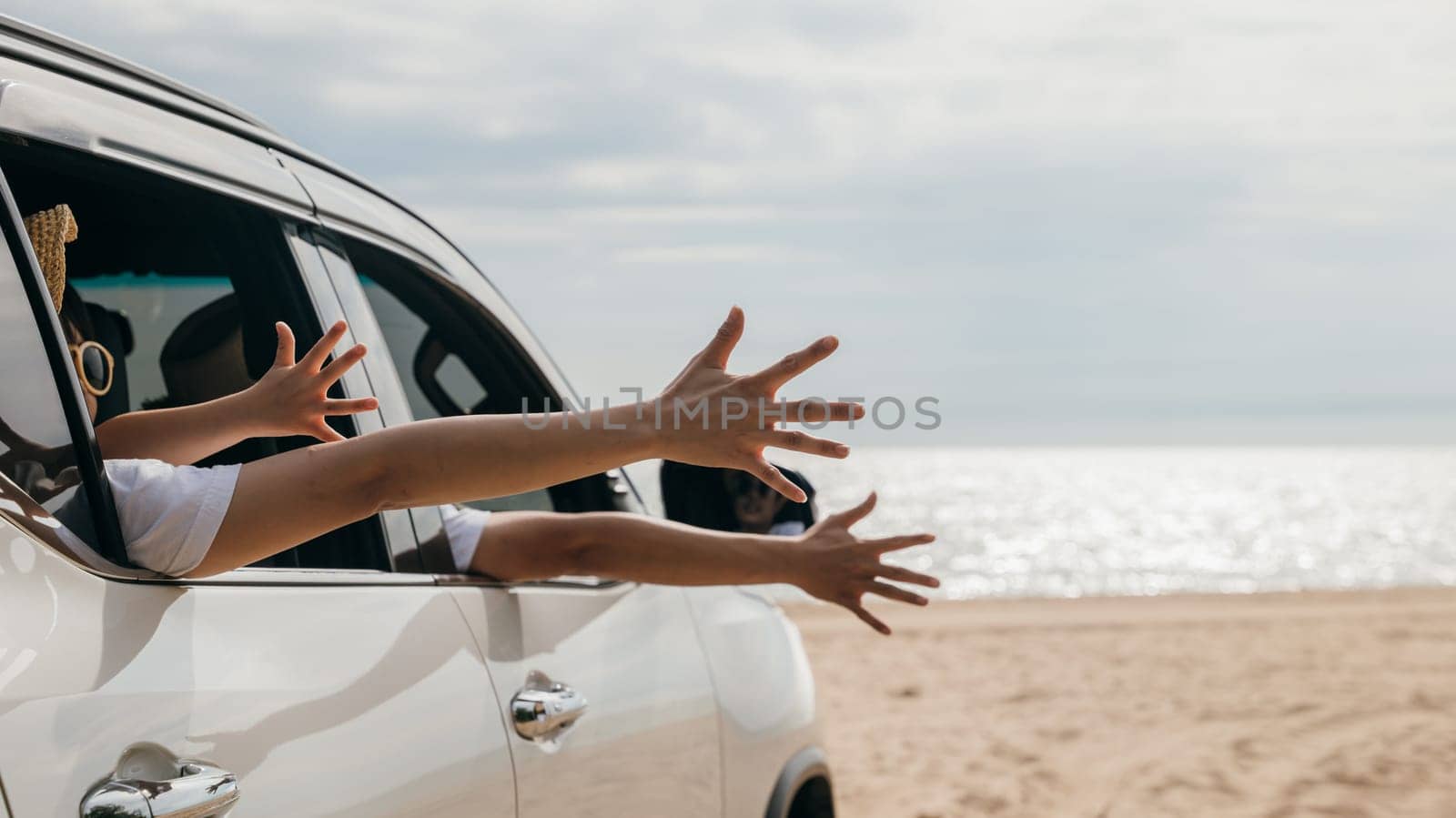 Happy family sitting in car waving hands travel outside car windows on beach travel by Sorapop