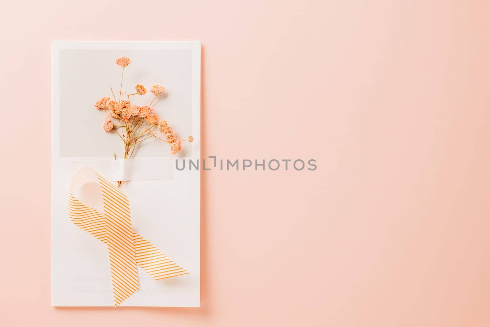 Pink awareness ribbon sign and paper card flower of World Cancer Day by Sorapop