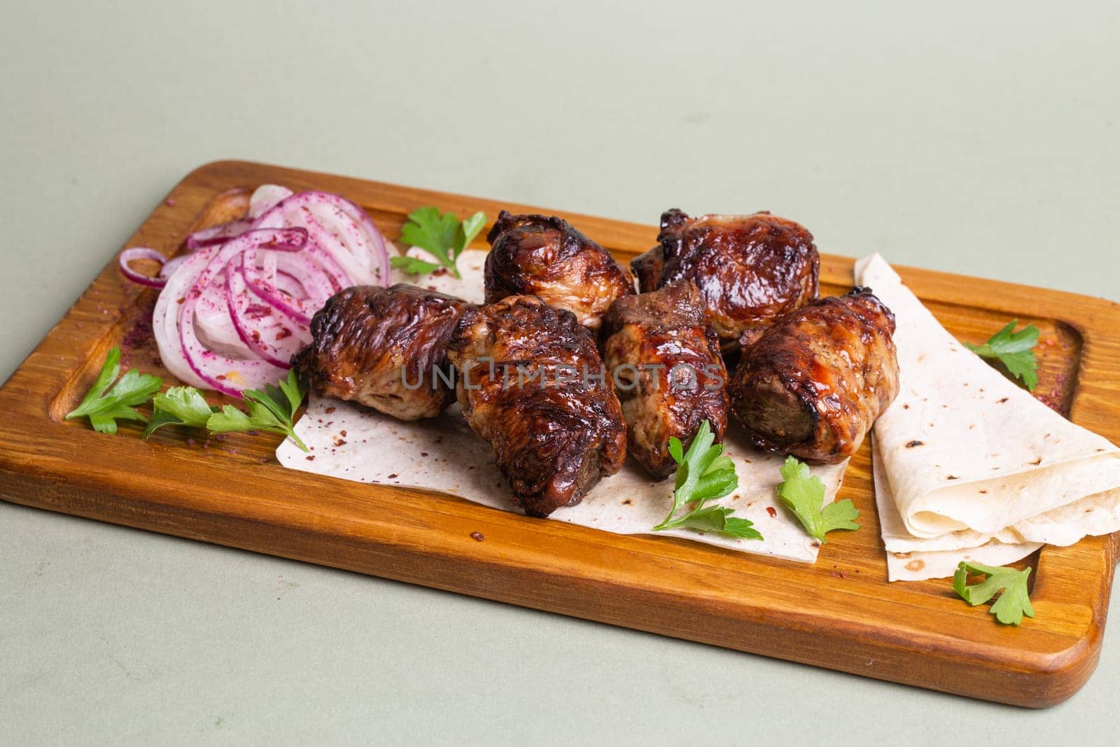 Lamb skewers with grilled vegetables and herbs on a wooden board. by Pukhovskiy