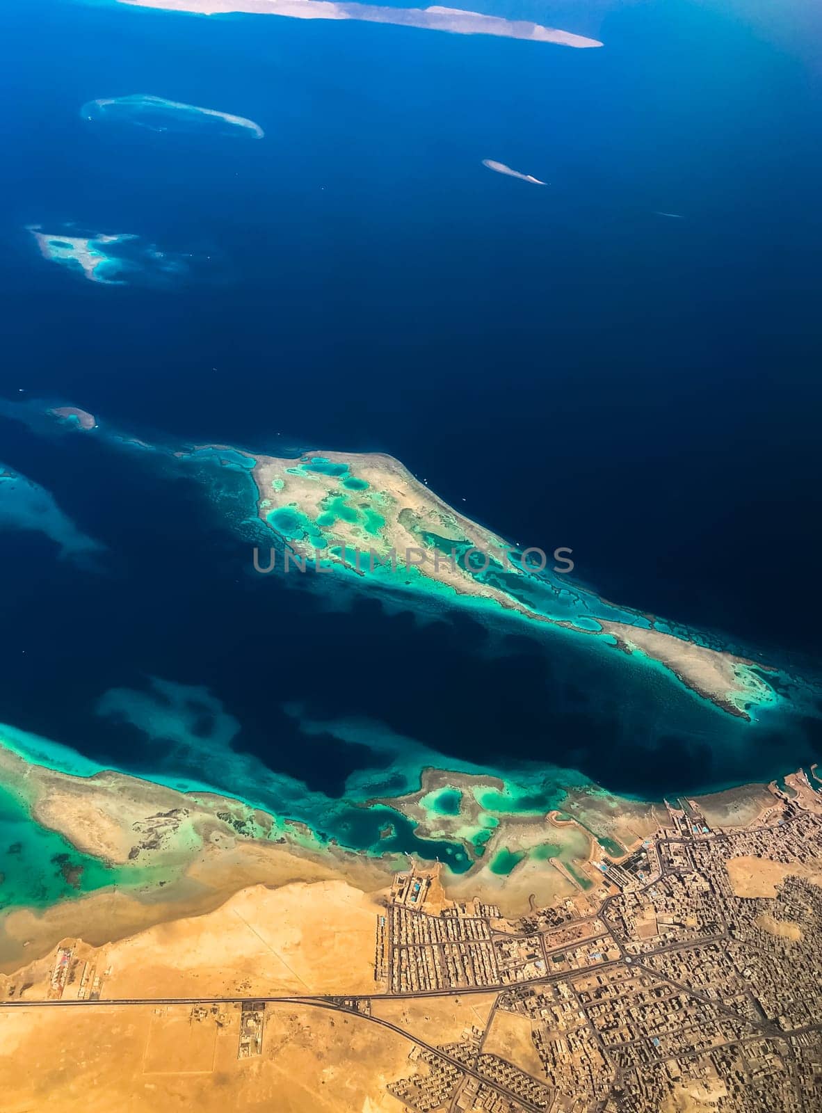 Aerial top view from airplane coastline Egyptian Desert islands. Red sea Sharm Al Sheikh Egypt. Amazing shoot bird eye plane window mountains. Travel concept. aircraft flying over ocean