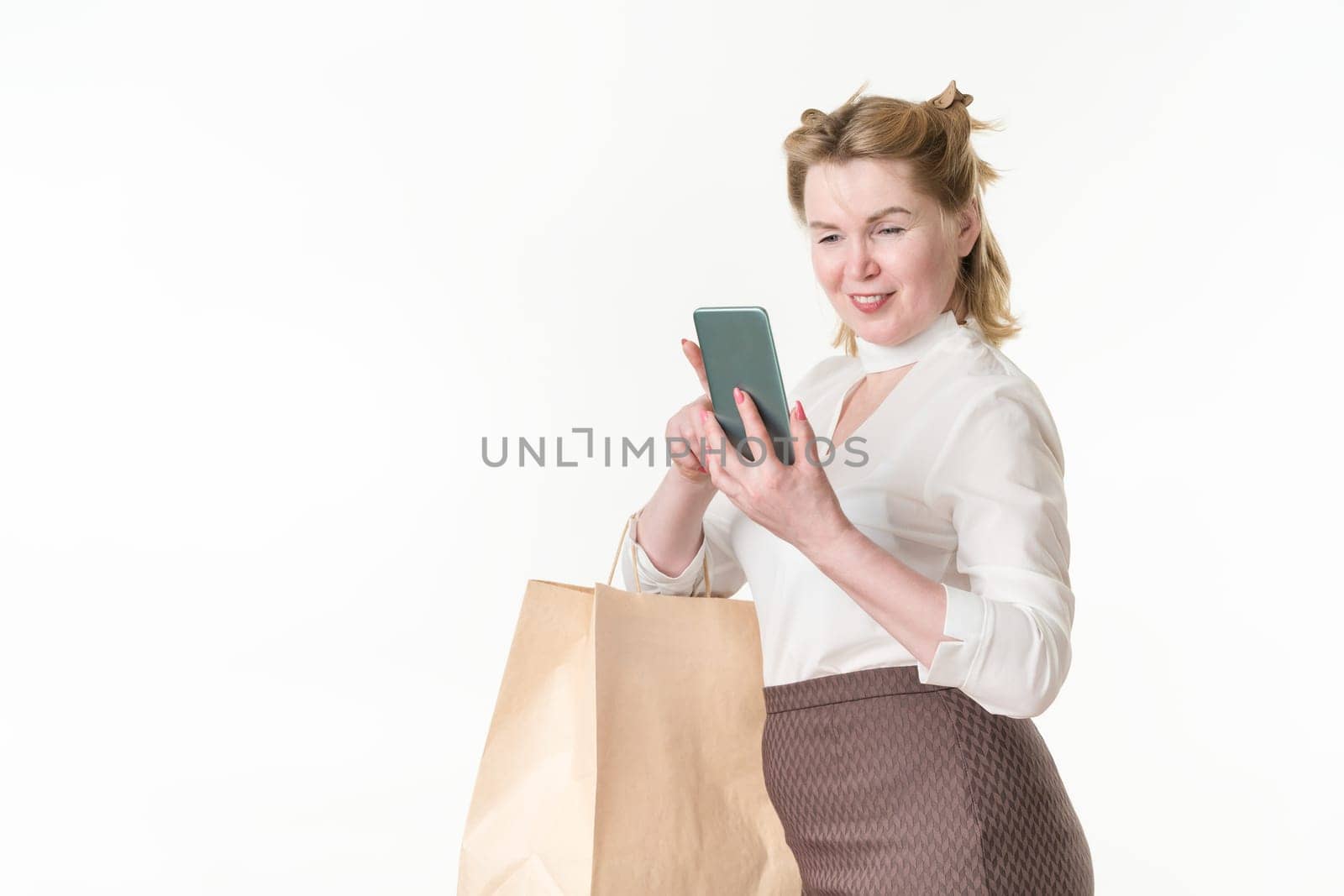 Cheerful woman holding smartphone reading online messages, browsing offers with sales and discounts by Alexander-Piragis