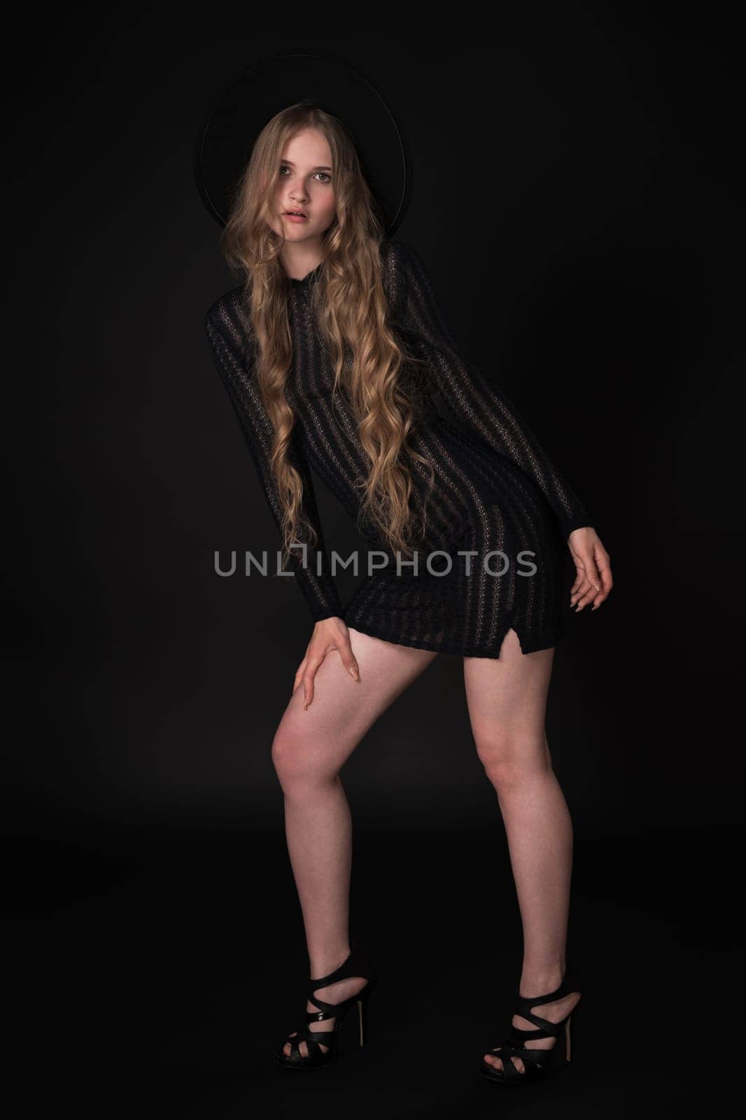 Full length portrait of sexy blonde young woman with long legs on black background by Alexander-Piragis