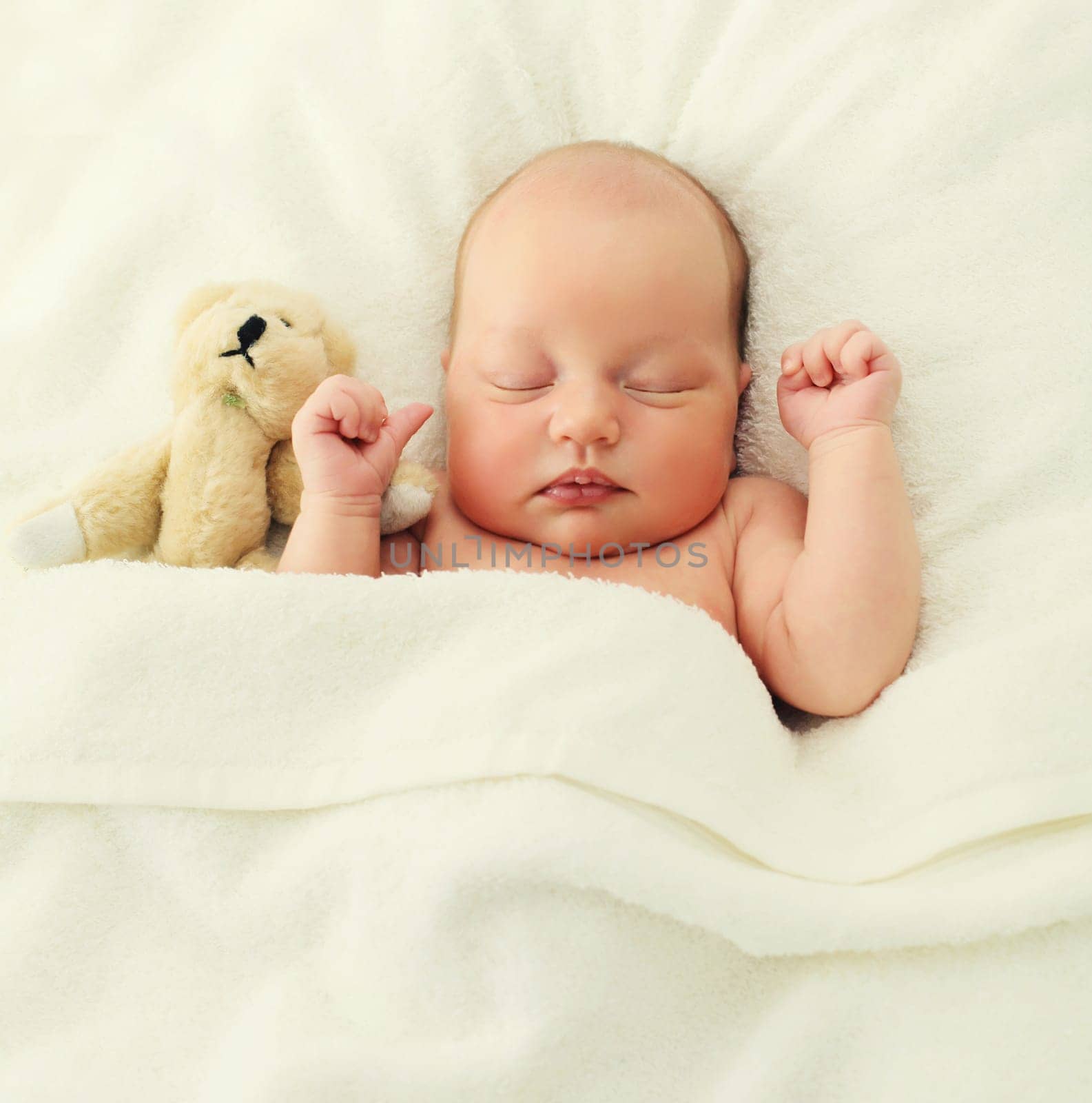 Portrait of infant sweet sleeping with teddy bear toy lying under blanket together on bed at home