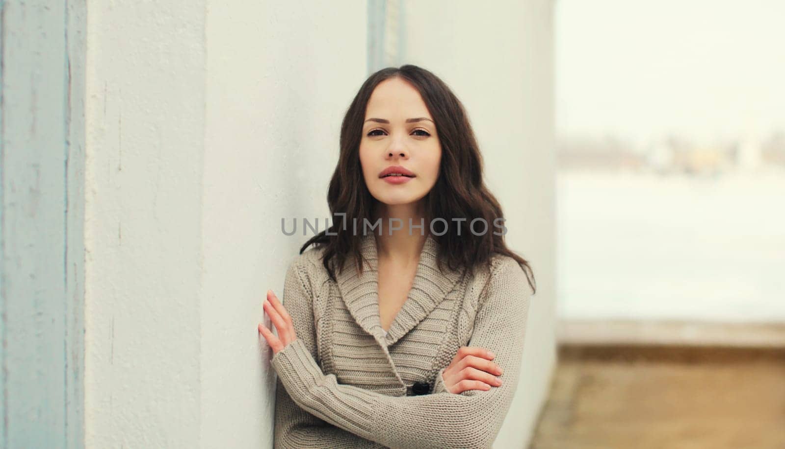 Portrait of beautiful caucasian brunette young woman posing on city street