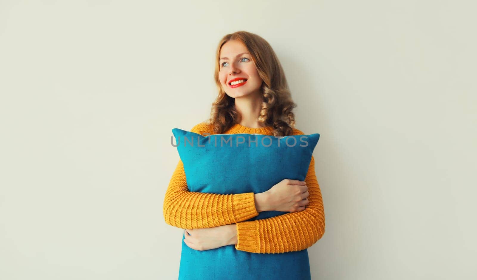 Healthy sleep, happy young woman hugs her soft comfortable pillow imagining that she is lying on the bed