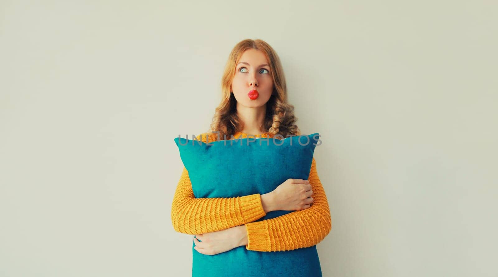 Healthy sleep, happy young woman hugs her soft comfortable pillow imagining that she is lying on the bed