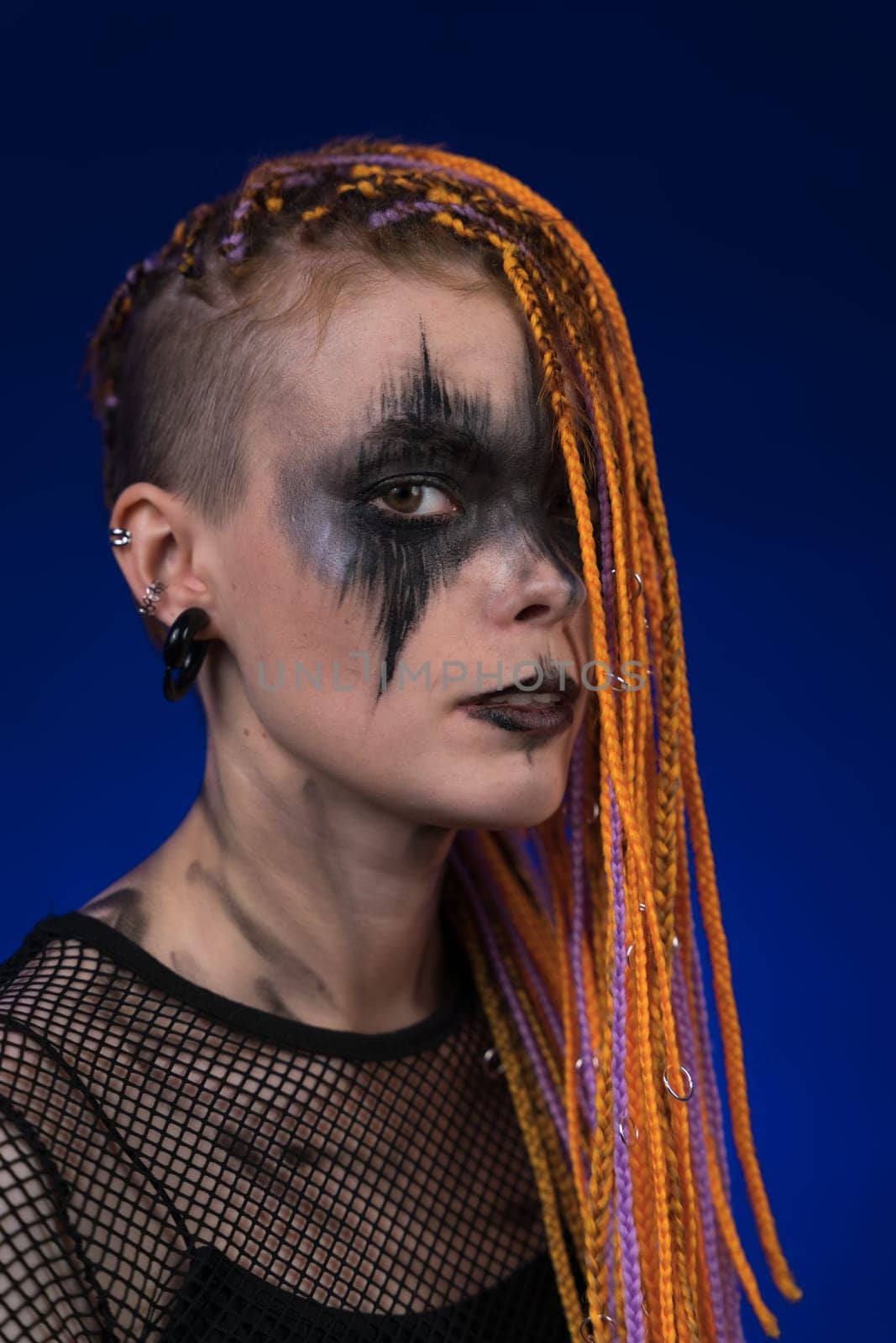 Dramatic portrait young woman with horror black stage makeup painted on face, dreadlocks hairstyle by Alexander-Piragis