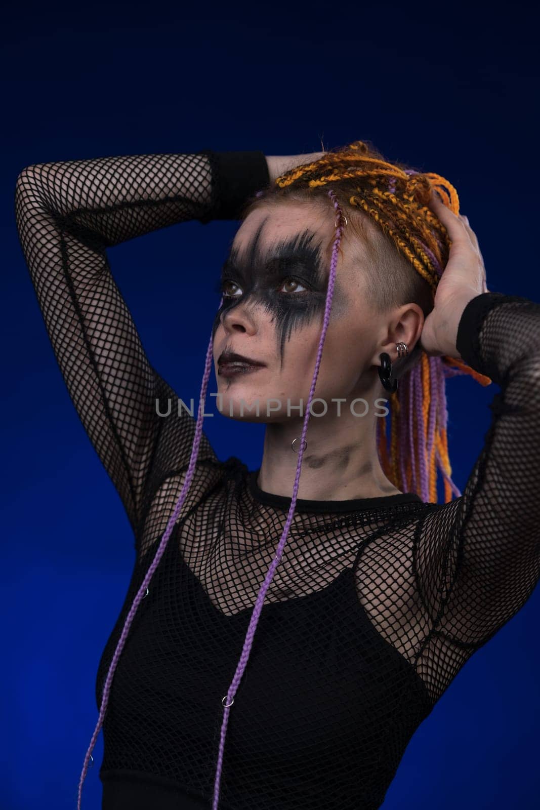 Cinematic portrait of young woman with orange braids hairdo and horror stage make-up painted on face by Alexander-Piragis