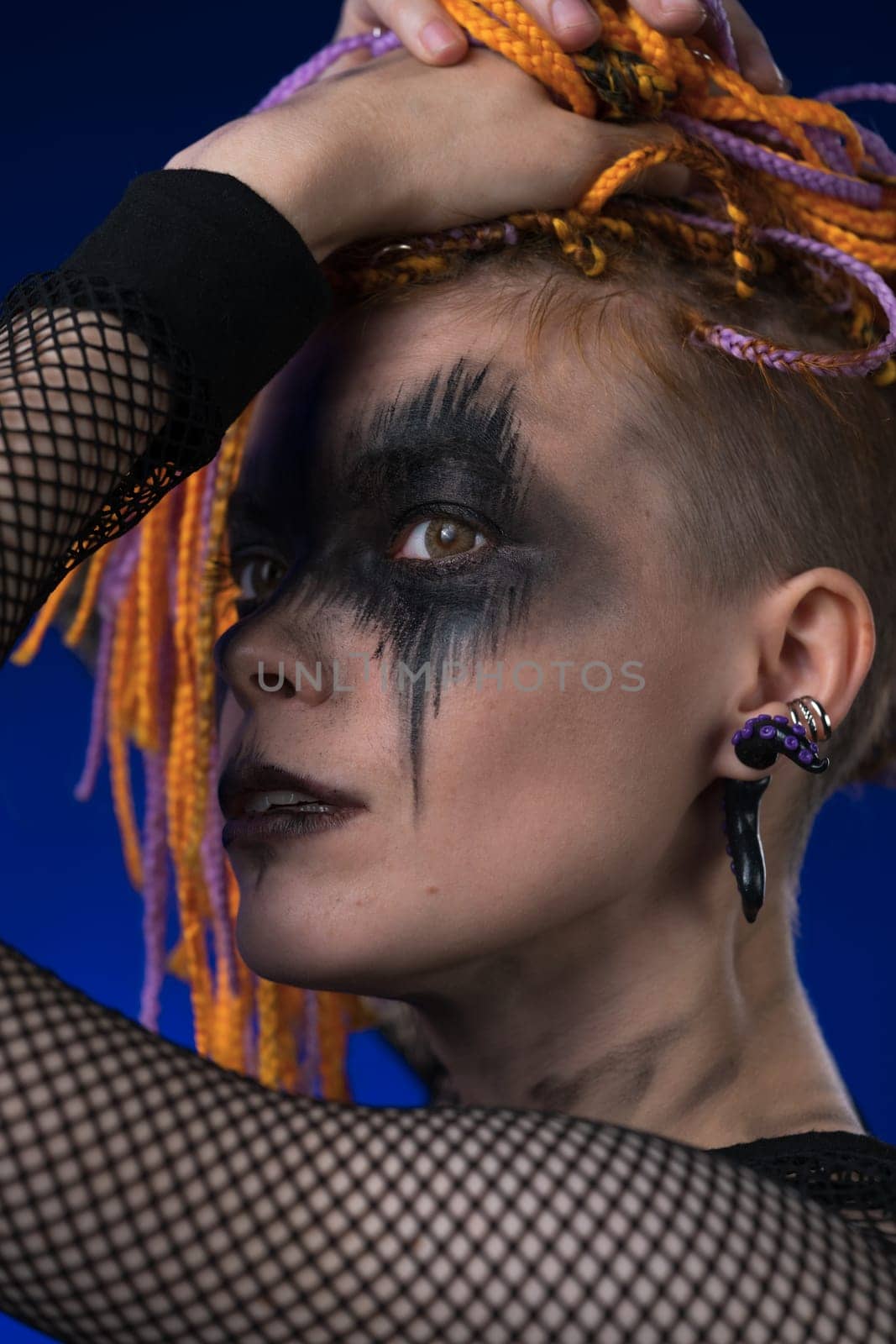 Fine art portrait beauty woman with colored dreadlocks and spooky black stage makeup painted on face by Alexander-Piragis