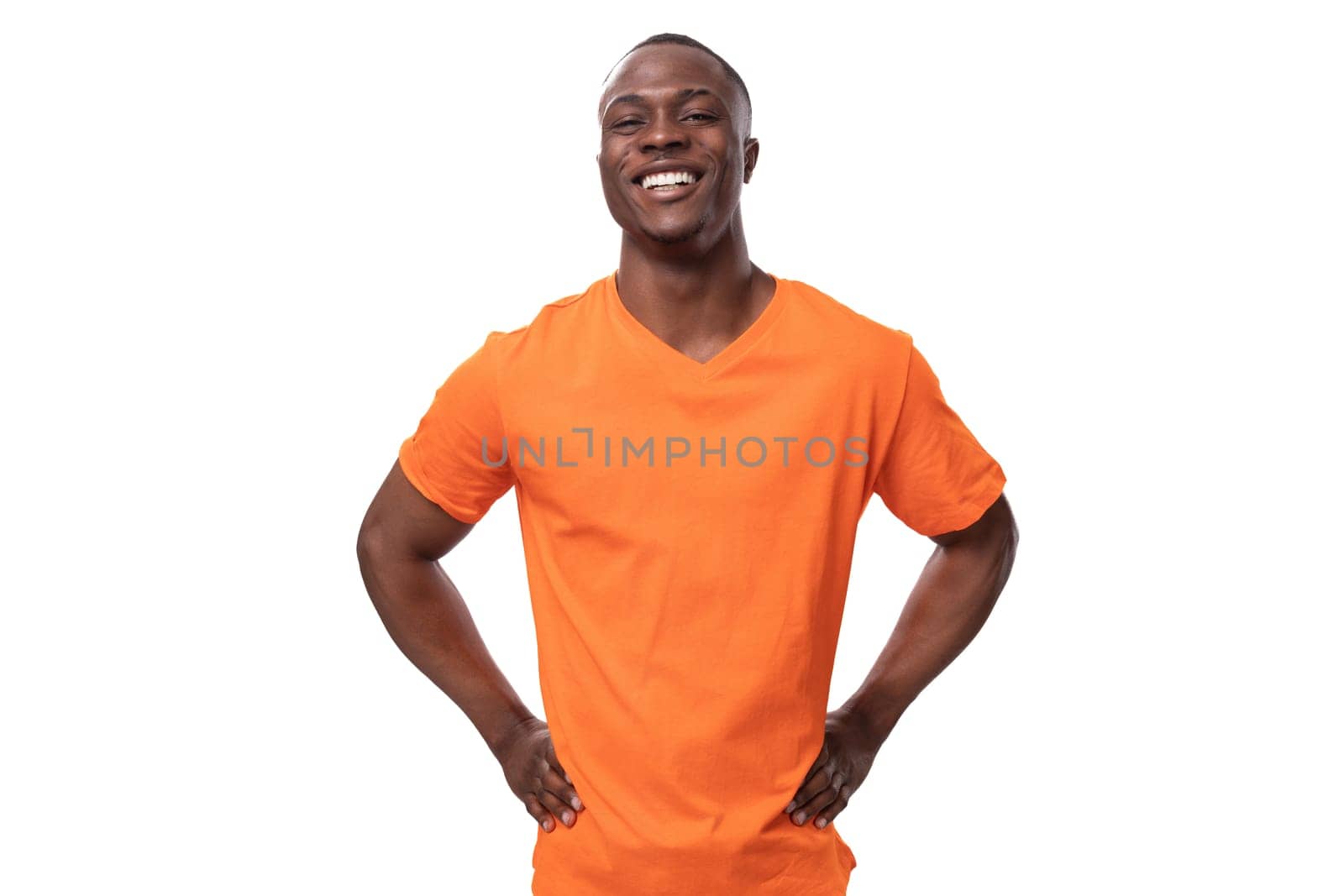 young cheerful african man in orange t-shirt smiling broadly on white background.