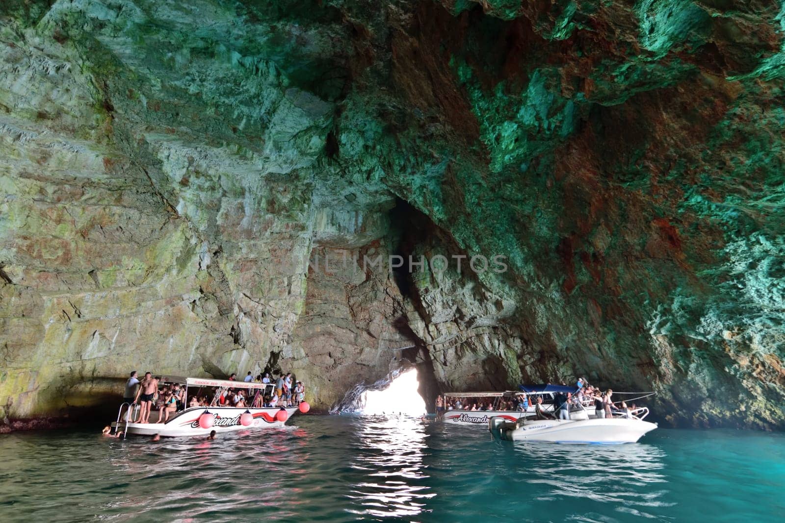 Kotor, Montenegro - June 10. 2019. Boats with tourists in Blue Cave , the tourist attraction by olgavolodina